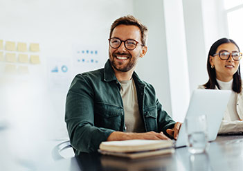 Man and woman sitting in a bright office