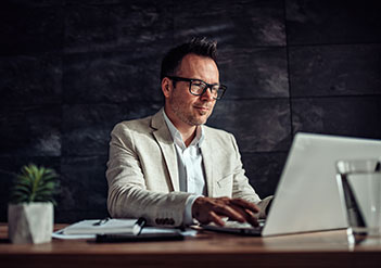 Man working on his laptop in a dark office